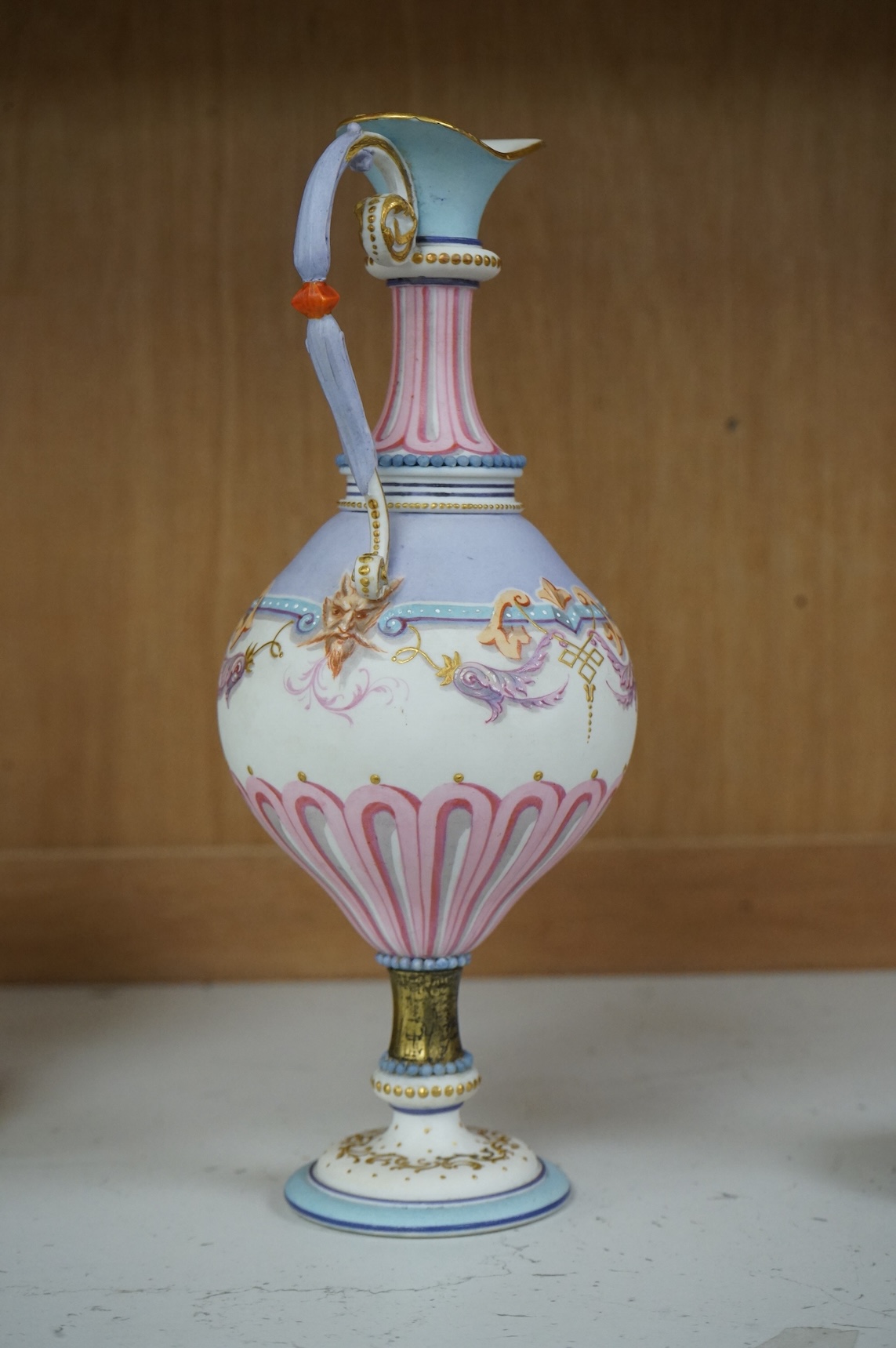 A 19th century Paris porcelain neo-classical pedestal ewer decorated with satyr mask and scrolls, 24cm high